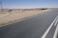 the view from a speeding motorcycle on an empty desert highway with a person riding an automobile