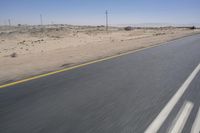 the view from a speeding motorcycle on an empty desert highway with a person riding an automobile