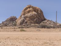 there is a large rock sitting in the desert with no one around it and no one standing at it