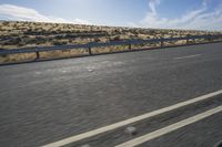 a motorcycle that is sitting on a highway in the middle of nowhere with the sun behind