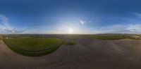 a 360 - view photo taken from a sky camera shows a road leading to a farm