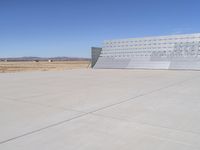 an airplane sitting in an airport next to the runway with no clouds or rain on it