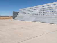 an airplane sitting in an airport next to the runway with no clouds or rain on it