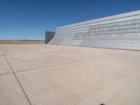 an airplane sitting in an airport next to the runway with no clouds or rain on it