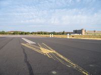 the airplane is traveling on an empty runway while it's in the air that appears to be painted with yellow chalk