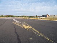 the airplane is traveling on an empty runway while it's in the air that appears to be painted with yellow chalk