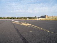 the airplane is traveling on an empty runway while it's in the air that appears to be painted with yellow chalk