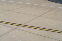 the airplane is getting ready for take off on the runway at an airport with brown grass and blue sky