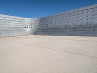 a man skateboarding inside the middle of an outdoor space filled with concrete blocks and concrete walls