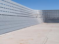 a man skateboarding inside the middle of an outdoor space filled with concrete blocks and concrete walls