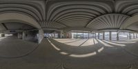 a panoramic image of an airport lobby from inside it with a car park to the side