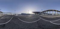 a fish eye lens photograph of a traffic light in the airport parking lot, with no one driving