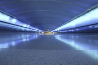 this photo shows an empty area in an airport walkway, at night time, the scene is blurry