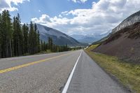 a highway on the side of the road with mountains in the background that has no cars