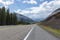 a highway on the side of the road with mountains in the background that has no cars