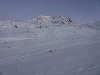 a mountain with lots of snow on it and lots of people skiing down the side