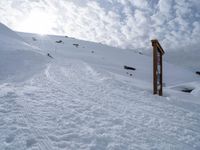 a snowboarder walks up a hill with his board up to the top of it