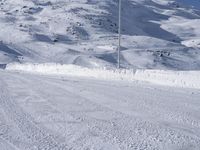 a lone man rides the snowboard on a track in front of a snowy mountain