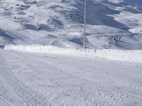 a lone man rides the snowboard on a track in front of a snowy mountain