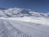 a lone man rides the snowboard on a track in front of a snowy mountain