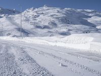 a lone man rides the snowboard on a track in front of a snowy mountain