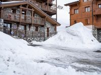 a ski lodge in the mountains of a village on top of a mountain, with snow piled to their ground and stairs