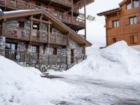 a ski lodge in the mountains of a village on top of a mountain, with snow piled to their ground and stairs