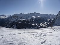 the mountains are covered in snow as people cross country ski by ski tracks through them