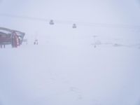 an image of a person skiing on the snow covered slopes near a ski lift and building