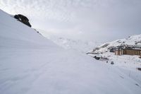 a man on skis in front of a snowy mountain range with buildings in the background