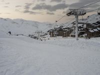 an empty ski slope with a gondola lift on top of it that is covered in snow