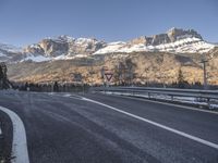 a sign warns of the mountains to be closed ahead as it travels uphill with snow on top