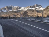 a sign warns of the mountains to be closed ahead as it travels uphill with snow on top