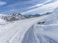 a mountain slope with snow piled up on the sides and behind a mound of snow with a hole