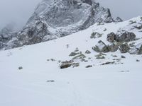 a mountain covered in snow with no people on it and rocks on it near a rocky peak