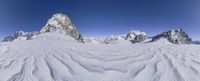 a snow mountain covered with snow with mountains in the background and snow on the ground