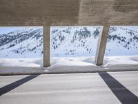 the shadow of two people and a snowboarder are seen from behind the railing