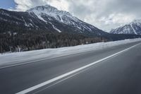 motion blurs the road as the vehicle makes its way down the mountain road with snow