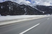 motion blurs the road as the vehicle makes its way down the mountain road with snow