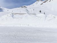 a person on skis going downhill on snow covered mountain top with snow covering the ground