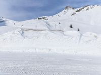 a person on skis going downhill on snow covered mountain top with snow covering the ground