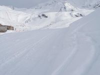 a skier going down a snowy slope by an alpine resort in winter attire with skis and poles