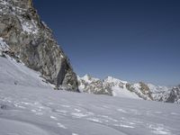 someone on their skis coming down a mountain, with a sky background and power lines in the air