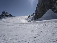 the man is skiing on the snowy mountain trail on his skis, and he's going downhill