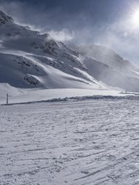 a lone skier is standing at the top of a slope in the snow as he prepares to run down a hill