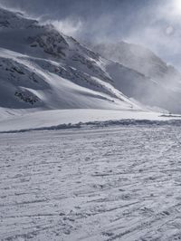 a lone skier is standing at the top of a slope in the snow as he prepares to run down a hill