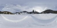 people are skiing down a snowy slope under clouds and sunshines in the sky above