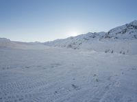 a snow boarder wearing red is going through a snowy mountain pass, all covered in white snow