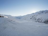 a snow boarder wearing red is going through a snowy mountain pass, all covered in white snow