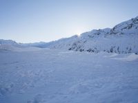 a snow boarder wearing red is going through a snowy mountain pass, all covered in white snow